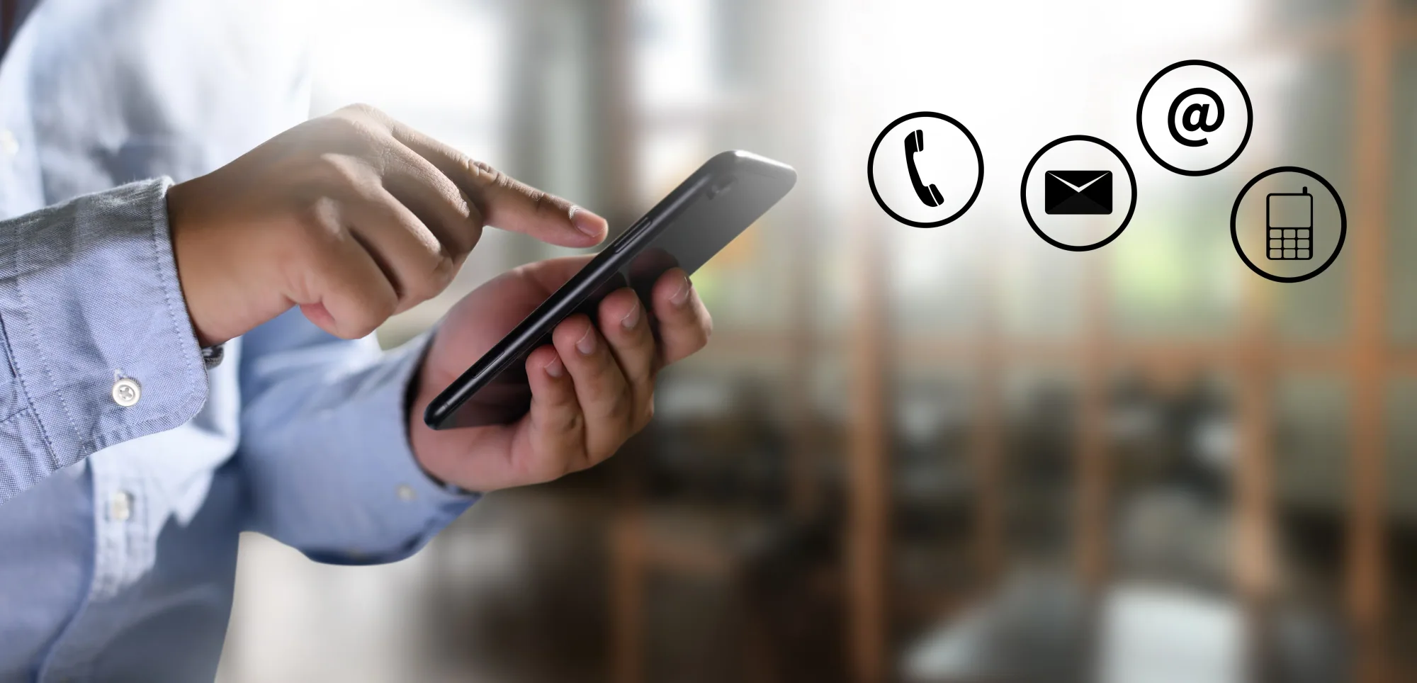 A person using a mobile phone, with outlined telephone, envelope and at-sign icons alongside.