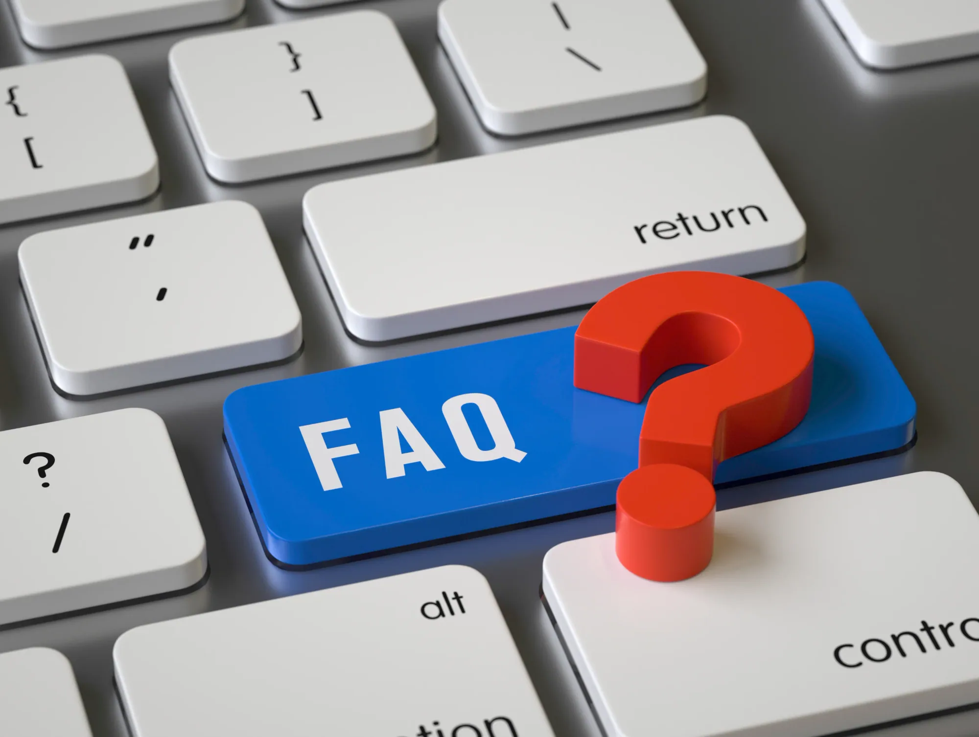 A close view of a computer keyboard with a blue key labelled FAQ and a red question mark resting on it.